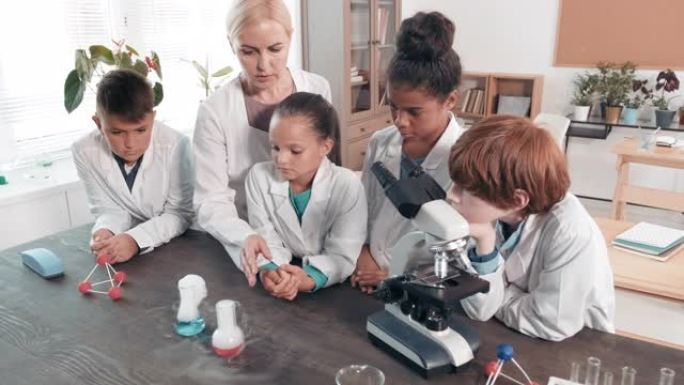女老师在科学课上向学童展示实验