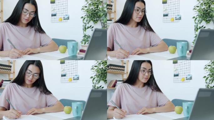 亚洲美女学生慢动作在家学习写字看笔记本电脑屏幕