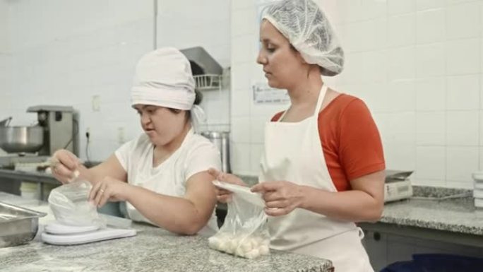 女工准备面食包，旁边有主管