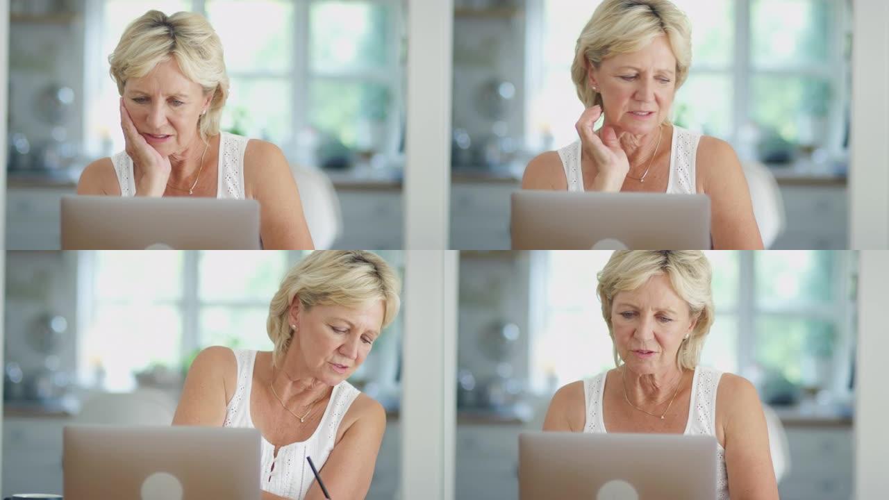 退休的高级妇女在家中使用笔记本电脑在网上购物或检查个人财务状况
