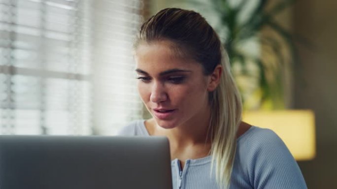 年轻成功的女商人的真实照片在办公室使用计算机时对自己在相机中的工作感到满意。