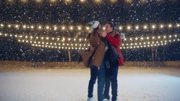 浪漫的冬天下雪的夜晚: 滑冰夫妇在溜冰场上玩得开心。双人花样滑冰男孩和女友在恋爱，跳舞，旋转，拥抱中