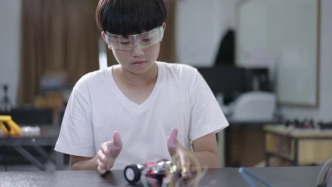 男孩建造和研究机器人STEM编程软件和修复