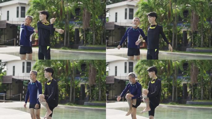 亚洲华裔高级男子和他的儿子在游泳课前在泳池边热身