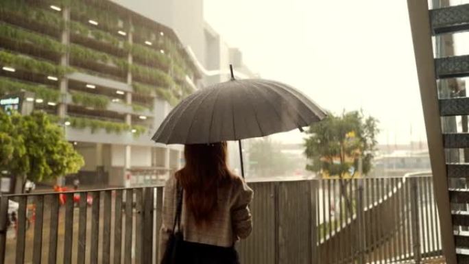 女商人在雨中撑伞时感到难过