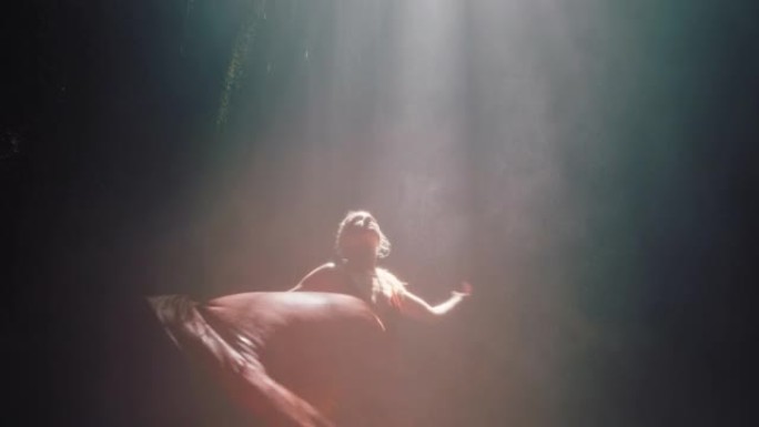 美丽的女人在瀑布洞里跳舞穿着漂亮的衣服享受舞蹈感受精神自由4k