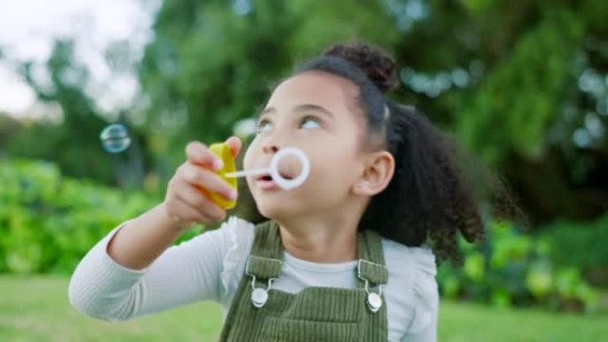黑人女孩孩子在公园、花园和大自然中吹肥皂泡，享受乐趣、快乐和童年发展、自由和在阳光下放松。兴奋的孩子