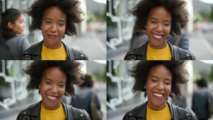 一个快乐而时髦的女人独自在城市里通勤时笑的肖像。一个美丽的黑人女性的脸，一个黑人微笑着，看起来很自信