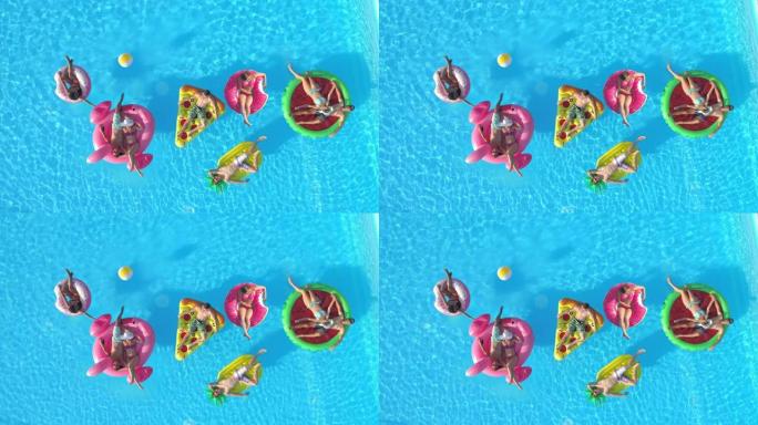 空中: 游客在五颜六色的漂浮物上放松，同时在游泳池享受阳光明媚的一天。