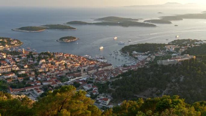克罗地亚。日落时岛屿城市的全景拍摄。航行在亚得里亚海的游艇。UHD