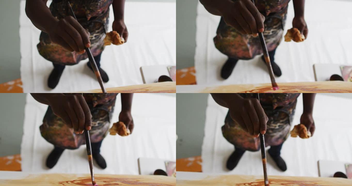 艺术工作室画布上非裔美国男性艺术家绘画中段的俯视图