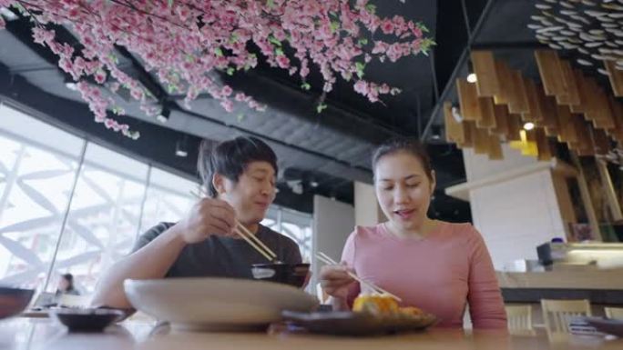 亚洲夫妇在餐厅吃日本菜