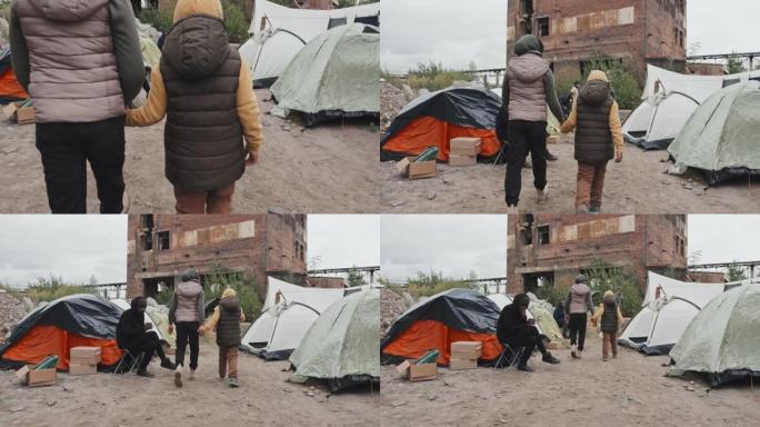 沿着帐篷城市散步的难民女孩