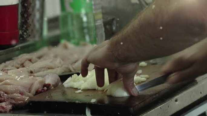 在拖船的厨房里，用刀将洋葱切成薄片的雄性手。特写。