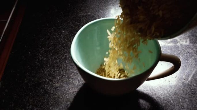 米饭落在桌子上的碗里，特写。