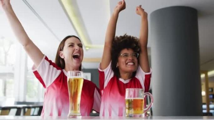 一群快乐的朋友在酒吧观看比赛，喝啤酒和拥抱