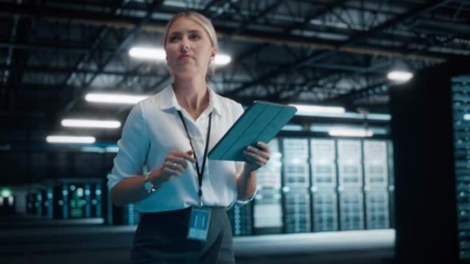成功的女性IT专家使用平板电脑，走过大仓库数据中心。计算云服务服务器。成功的电子商务数字企业家。手持