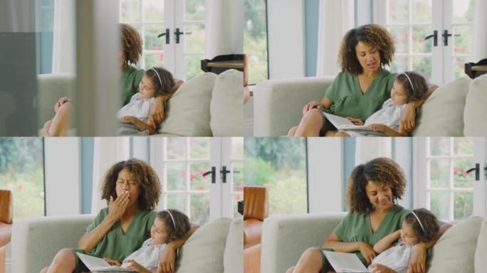 女儿坐在家里的沙发上与母亲一起读书，母亲打哈欠以显示其睡前-慢动作拍摄