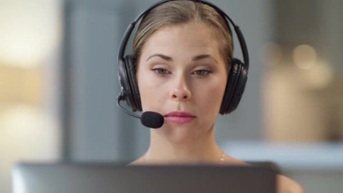 年轻漂亮的呼叫中心代理在办公室或家庭的笔记本电脑上进行虚拟视频通话时交谈。一个可爱的女性热线顾问接线