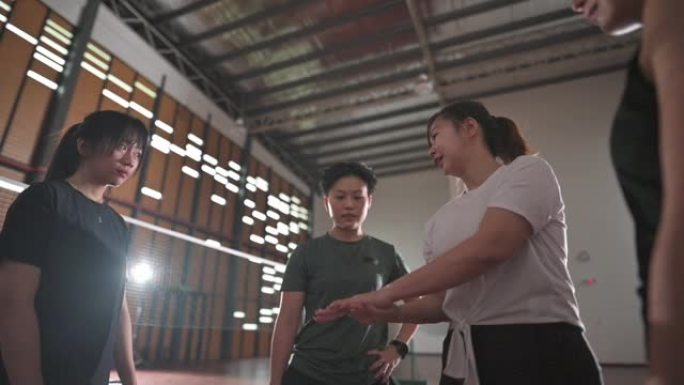 亚洲华人裁判和羽毛球运动员掷硬币在羽毛球场上决定