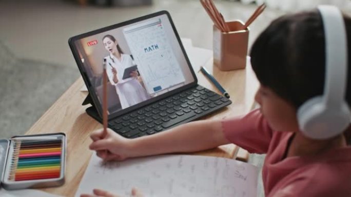 亚洲女生在家客厅通过电脑与老师和同学进行视频会议电子学习