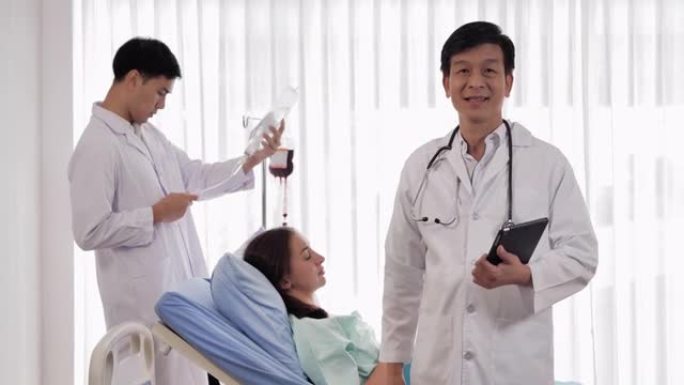 亚洲医生男性经验丰富的医生，一边看着相机独自在诊所摆姿势，一边自信地微笑。医生在视频会议上看。工作骄