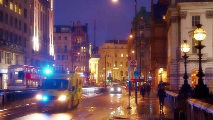 晚上安静的伦敦城市街道。人们路过。汽车。红色巴士。路灯。市街。