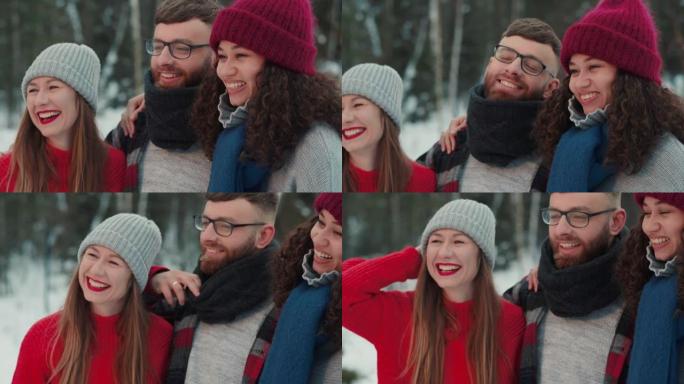 友谊概念。快乐的多民族年轻美丽的人微笑拥抱，在下雪的冬季森林慢动作中摆姿势。