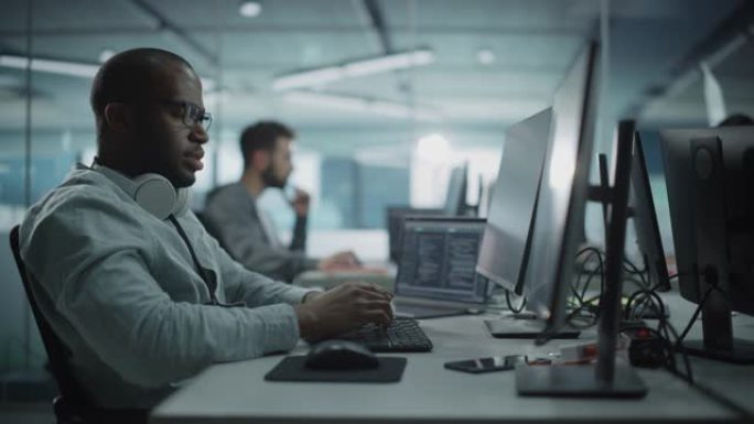 真实的办公室: 在台式计算机上工作的黑色IT程序员的肖像。男性网站，软件工程师开发应用程序，程序，视