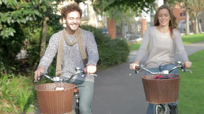夫妇一起骑自行车穿过城市公园
