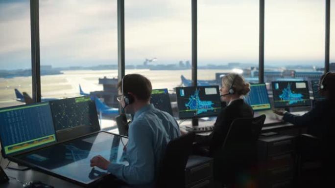 多元化的空中交通管制团队在现代化的机场塔中工作。办公室里满是台式电脑显示屏，配有导航屏幕、飞机起飞和