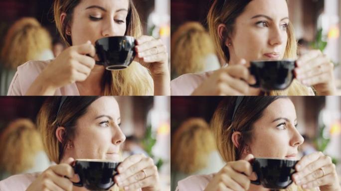 4k视频片段，一个迷人的年轻女子坐在咖啡馆里，一边喝咖啡一边沉思
