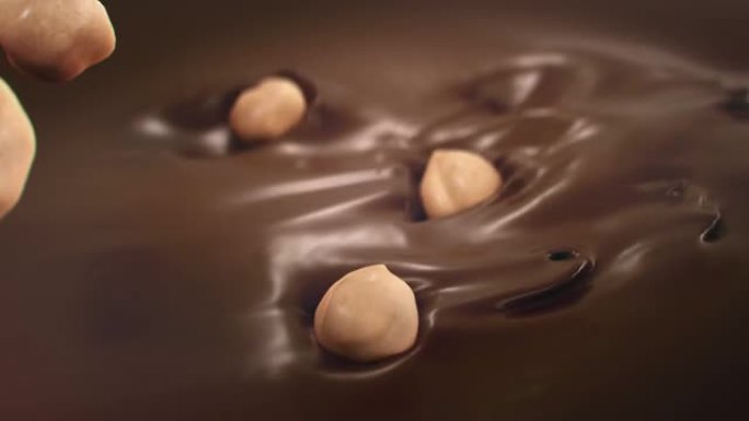 榛子在4k超慢动作中落入液体巧克力中