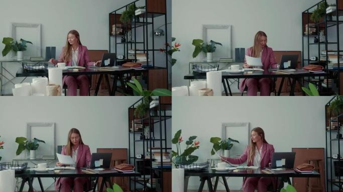 工作中的合作。两个漂亮严肃的年轻商务女性一起用笔记本电脑工作，在现代办公桌上忙碌。