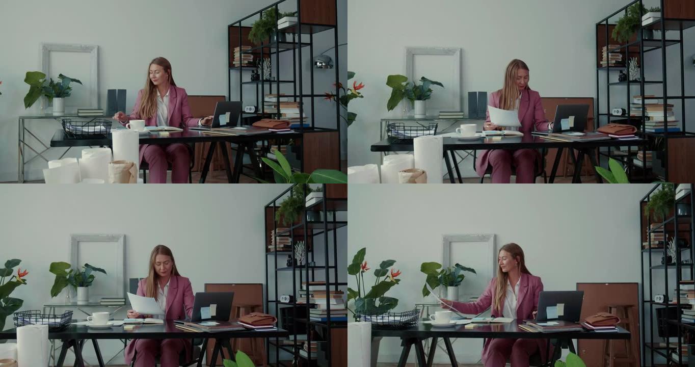 工作中的合作。两个漂亮严肃的年轻商务女性一起用笔记本电脑工作，在现代办公桌上忙碌。