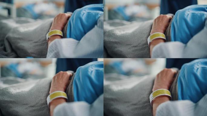 医院病床: 康复中的老病人躺在医院的病床上睡觉，她脆弱的手放在毯子上，信息腕带上。专注于手。情感深刻