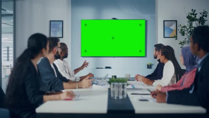 多民族办公室会议室会议: 成功的经理，高管交谈的多元化团队，使用绿屏色键电视。投资电子商务创业的商人