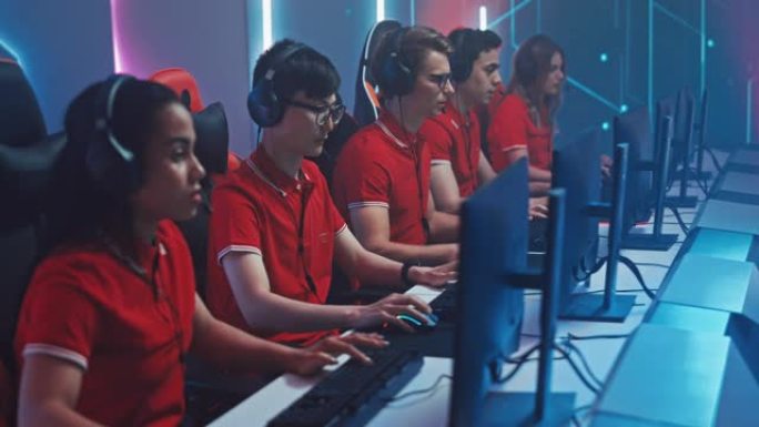 专业游戏玩家组成的多元化的Esport团队使用耳机在锦标赛上玩视频游戏。时尚霓虹灯网络游戏竞技场。锦