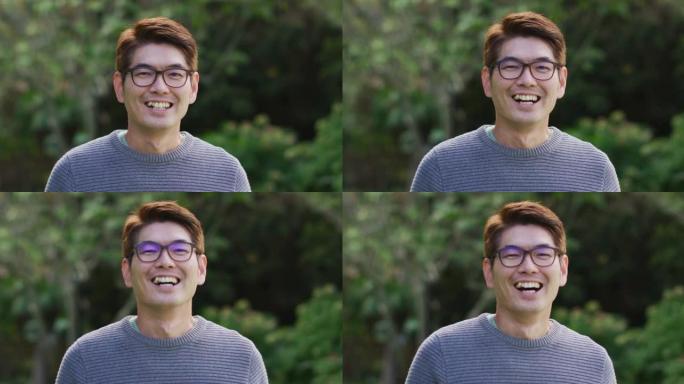 快乐的亚洲男人的肖像在花园里看着相机微笑和大笑