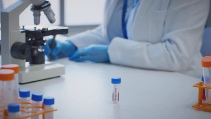实验室工作人员使用显微镜进行研究，将血液样品标记为ab型