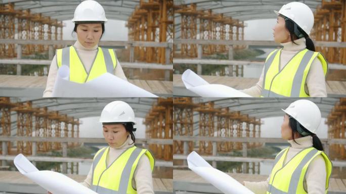 亚洲年轻女服务员在建筑工地学习蓝图的慢动作肖像