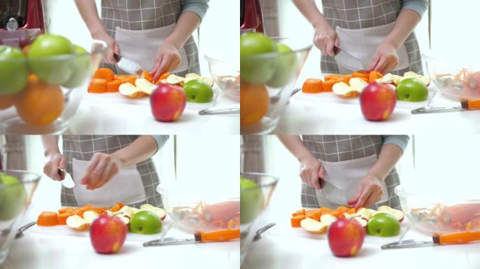 亚洲夫妇准备蔬菜和水果，并使用榨汁机进行冷榨果汁