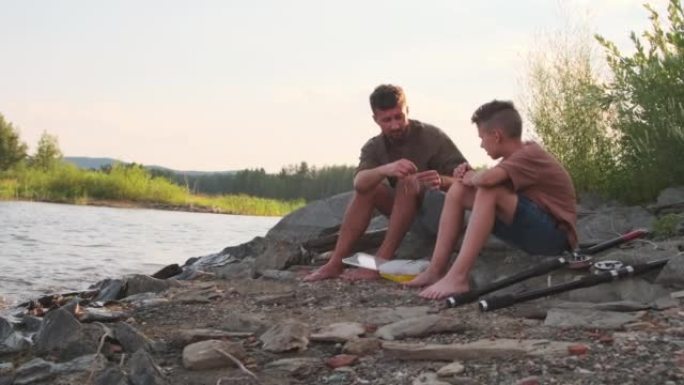 儿子和父亲坐在湖岸