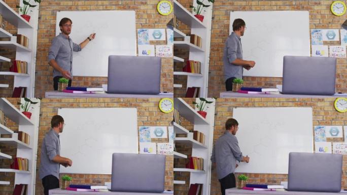 白人男老师在学校的教室里看着笔记本电脑时教授化学