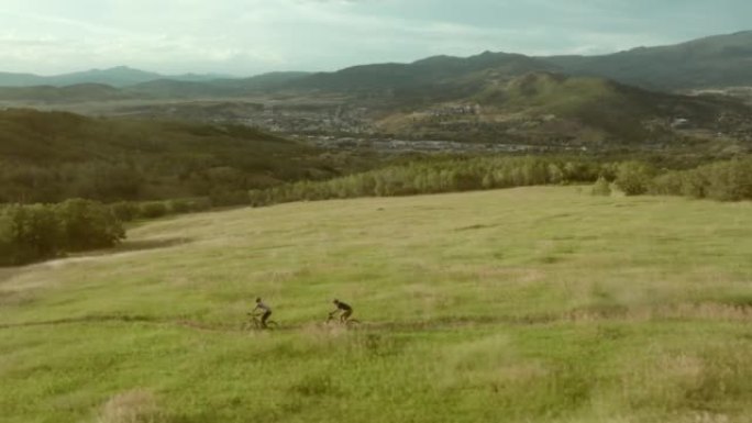 两人骑自行车的鸟瞰图，日落时分的山地自行车