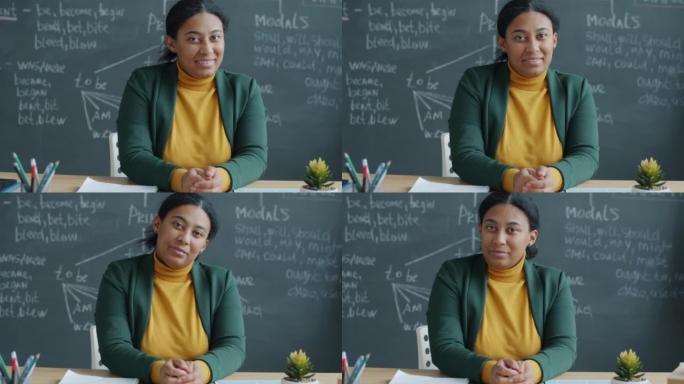 非洲裔美国女英语老师在教室里微笑的慢动作肖像，背景是黑板