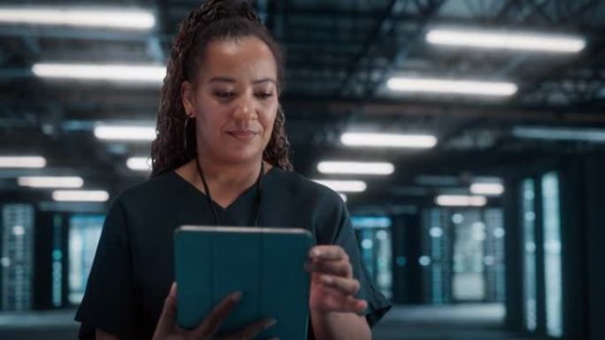 黑人女性首席技术办公室使用笔记本电脑，站在大仓库数据中心。使用SAAS、云Web服务的系统管理员。电