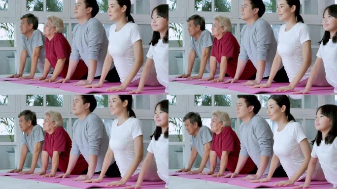 亚洲的多代家庭做瑜伽到家庭锻炼。家庭，生活方式，人，多代，老人，假期，关系，孩子，退休，健康护理，领