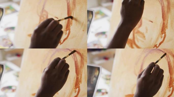 非裔美国男性画家在艺术家工作室的画布上绘画