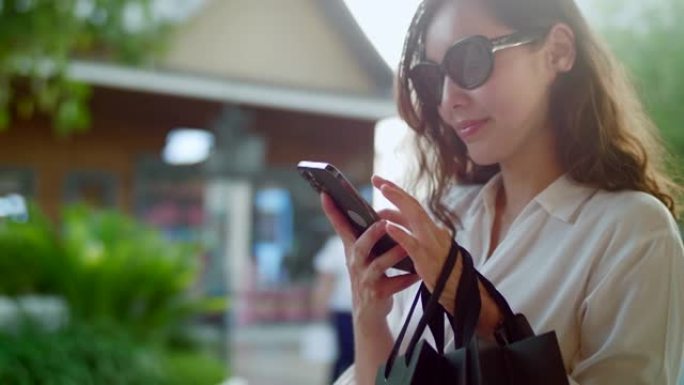 年轻女子使用智能手机在商店自助购物